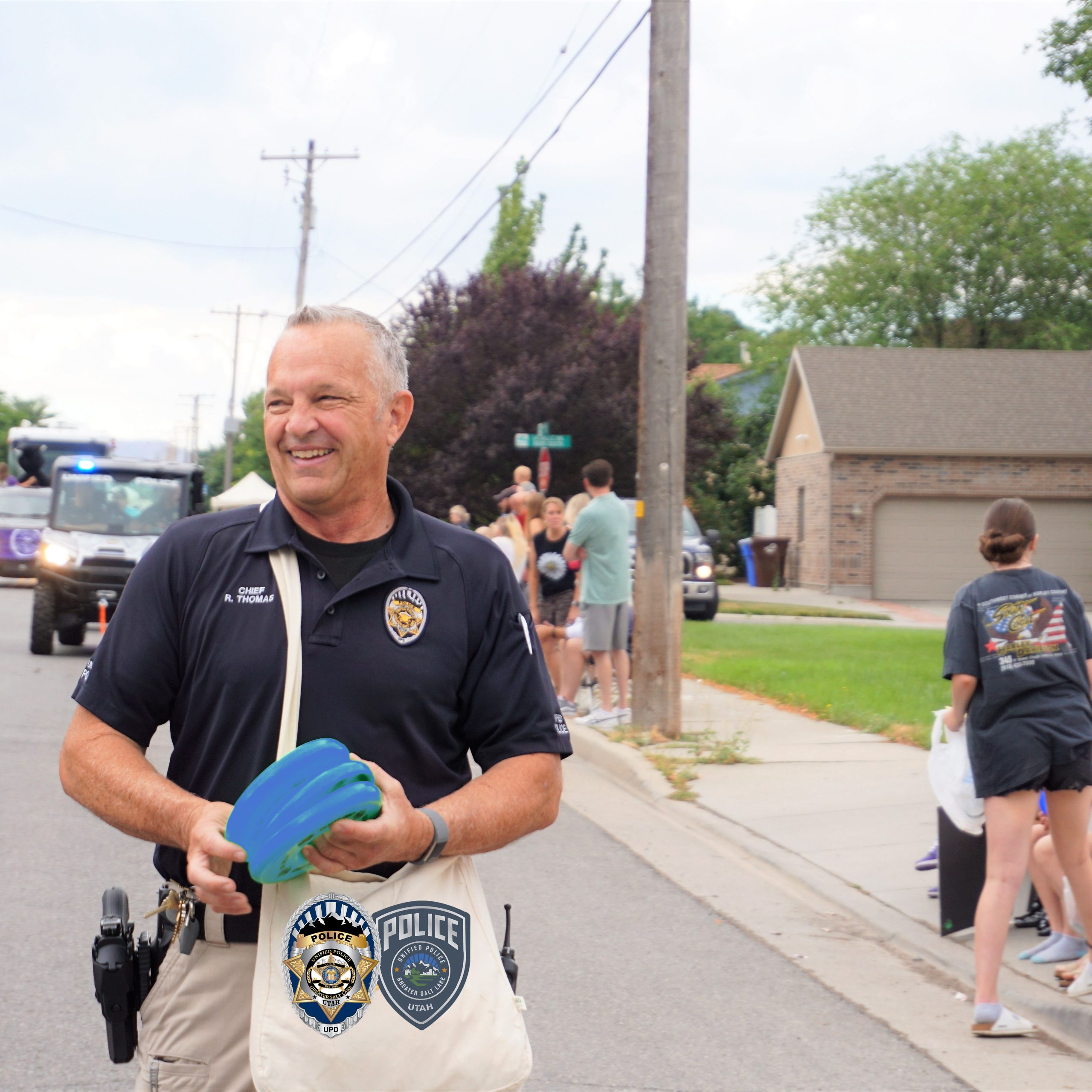 Chief Thomas at Midvale Parade handing out items to kids at parade